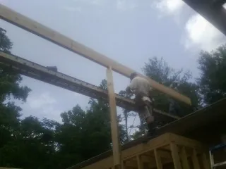 Carpenter setting a ridge beam over a new addition frame — Ice Dam Removal by Roofing Brothers in Matheson