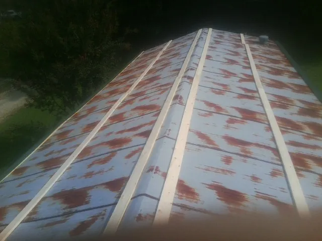 Rusted metal roof panels with new wood purlins before replacement — Storm Damage Roof Repair in Matheson by Roofing Brothers
