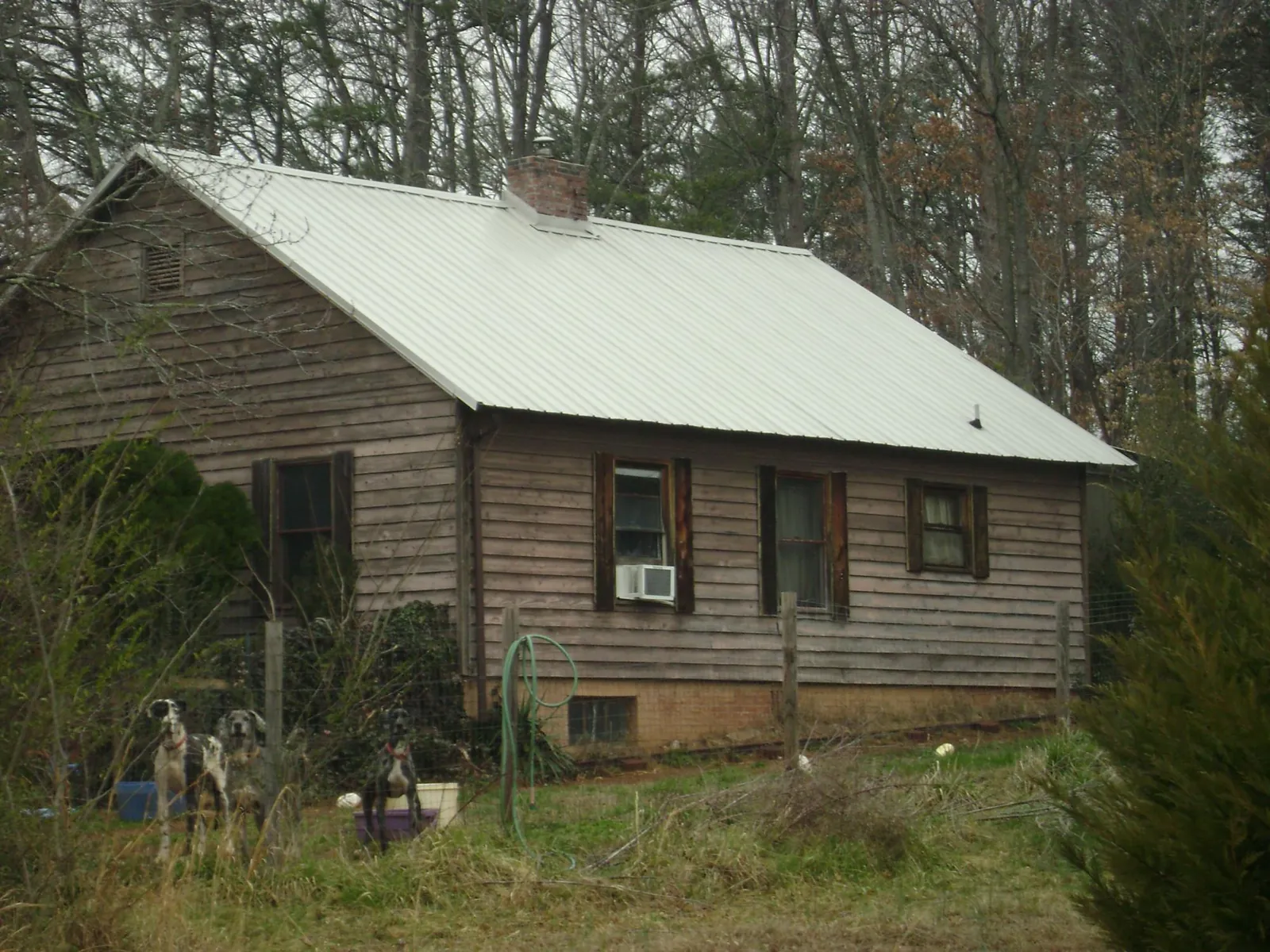 White metal roof on an old wood sided farmhouse, from a Metal Roof Installation job in Matheson